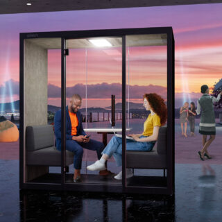 Two colleagues engaged in conversation inside a Silen meeting pod.